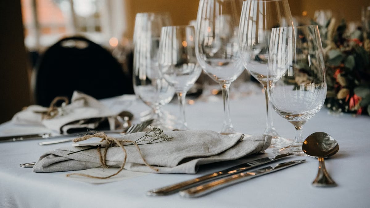 A classy table setup with fine cutlery, napkins, and elegant wine glasses ideal for formal dining.